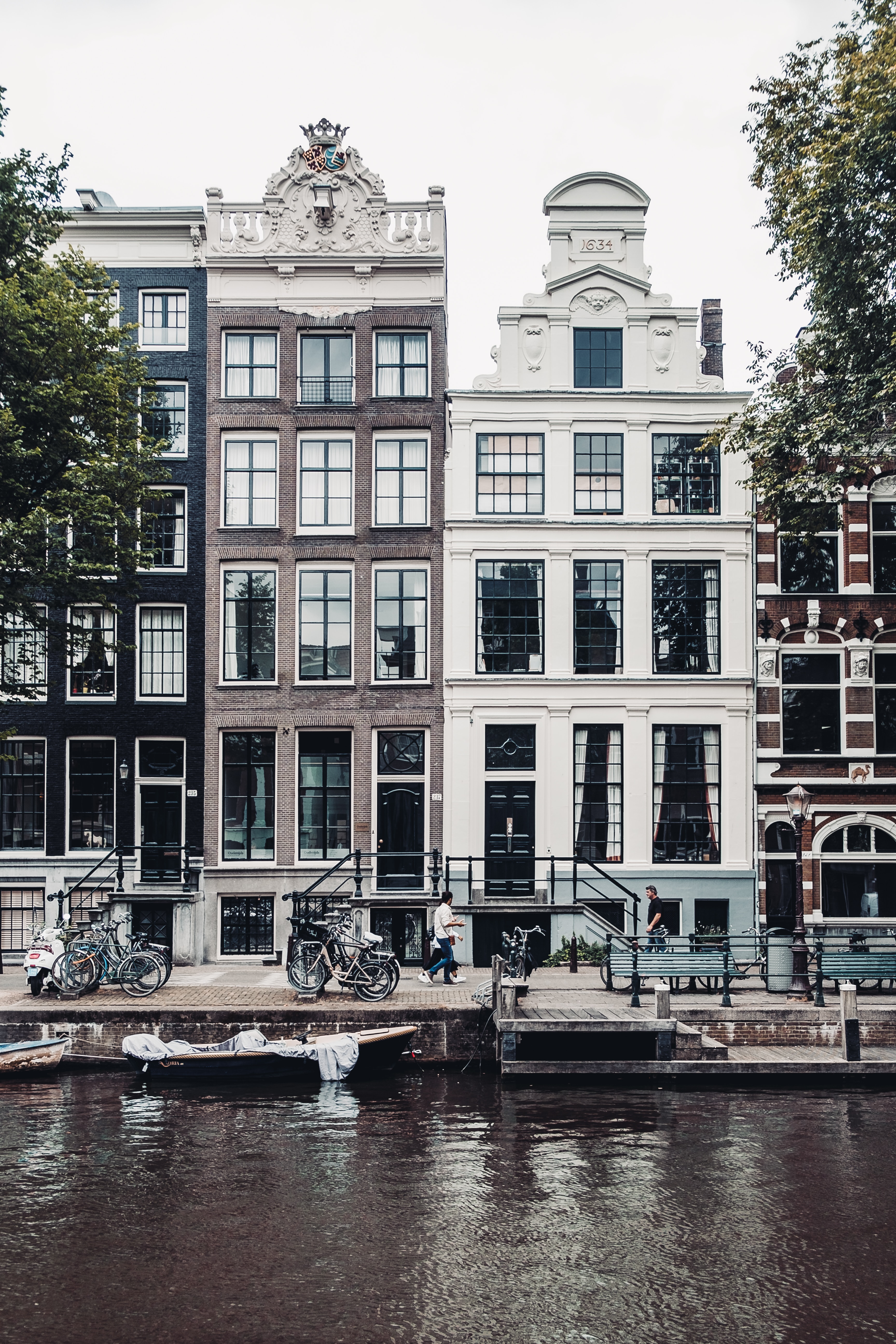 Amsterdam, The Nederlands, Houses along a canal (credit: Photo by Robin Benzrihem on Unsplash)